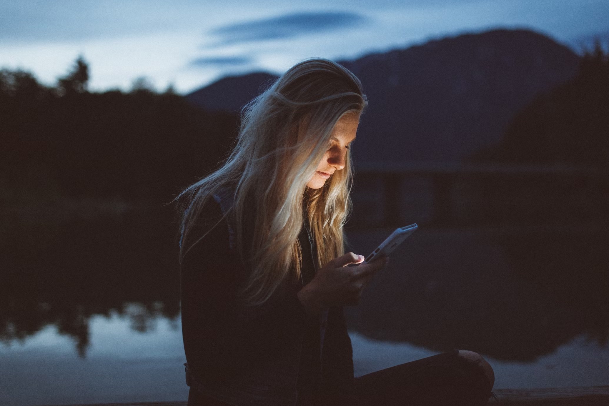 Mulher a usar smartphone no meio de um lago